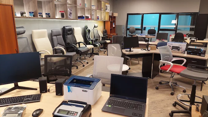 Showroom con sillas, monitores, impresora y notebooks